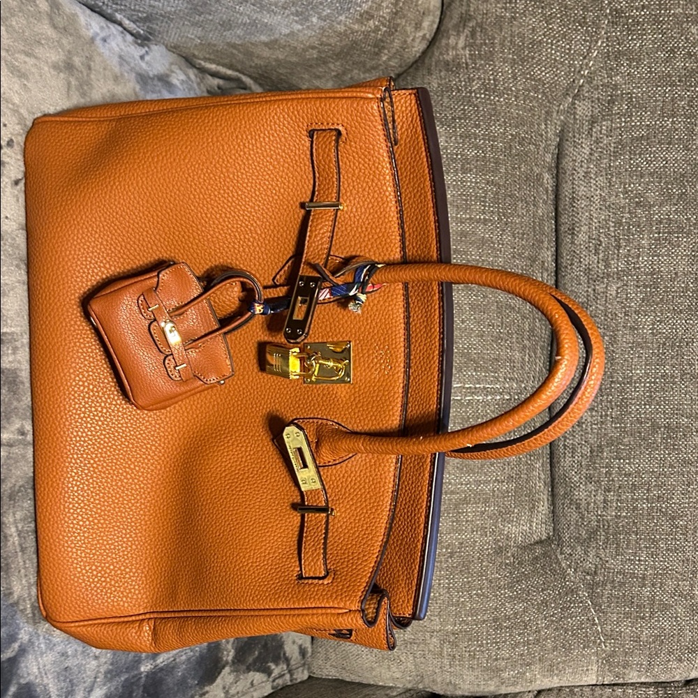 Elegant tan Leather Handbag with a miniature bag charm that matches.